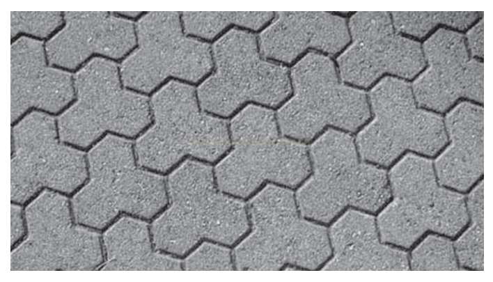 Fotografia de um piso de placas hexagonais encaixadas, formando um padrão contínuo.