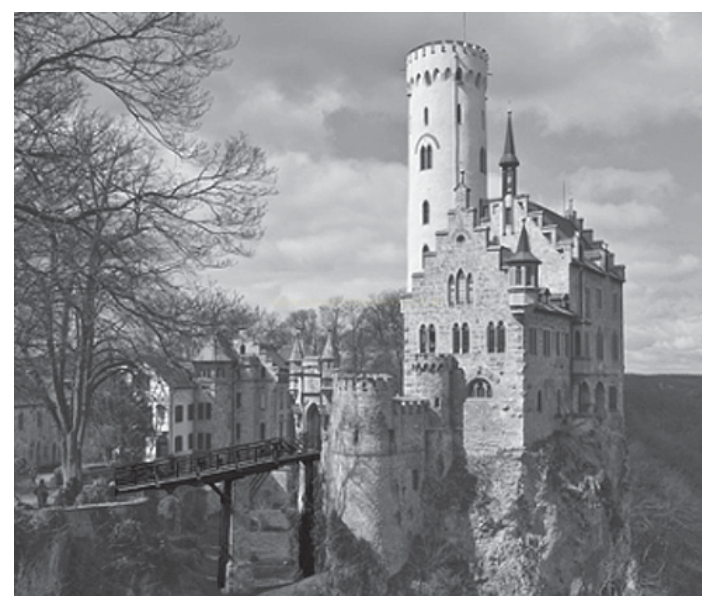 Fotografia em preto e branco de um castelo de torre alta sobre um rochedo, com ponte metálica.